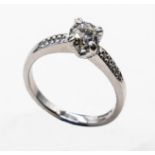 An 18ct white gold 72pt diamond solitaire ring with 10pt diamond shoulders