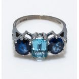 An 18ct white gold three stone sapphire and aquamarine ring with diamond shoulders