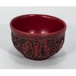 A red carved Chinese bowl