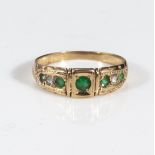 An 18ct gold seven stone emeralds and diamond ring