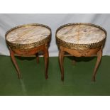 A pair of small French tables with brass mounts and marble tops.