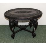 An antique carved Indian table the legs are carved as elephant heads with tusks