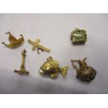 Six 9ct gold and yellow metal pendants and charms to include a fish with a pearl in its mouth, a