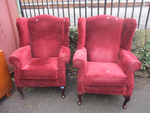 A pair of modern, red upholstered, wing back armchairs