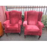 A pair of modern, red upholstered, wing back armchairs