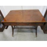 A mahogany library table having a rectangular top with drop ends and cross banded edge, two frieze