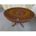 A hardwood occasional table, the oval top with pierced leaf and inlaid metal decoration on a