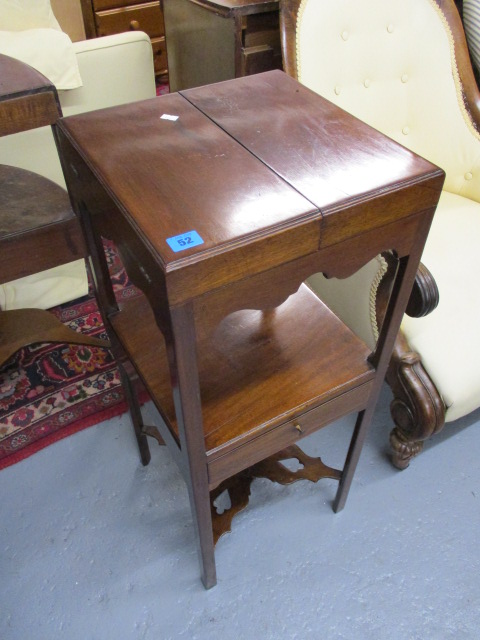 A George III mahogany wash stand having a twin panelled, hinged top over a shelf and a drawer, 35h x