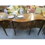 A reproduction mahogany serpentine-fronted sideboard, with a cutlery drawer above a single central