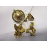 Four 9ct gold and yellow metal pendants and charms to include a globe, a Trojan horse, a figure