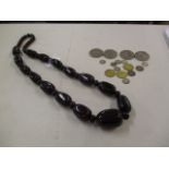 A black and red beaded necklace, together with a small quantity of coins