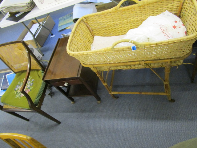 A caned wicker work Moses basket on a cane and bamboo stand, with bed linen, a mid 20th century