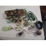 Mixed beaded jewellery to include jade bangles, necklaces, a small mirror and other similar items