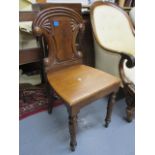 An early Victorian mahogany, carved, panelled back hall chair, raised on turned forelegs
