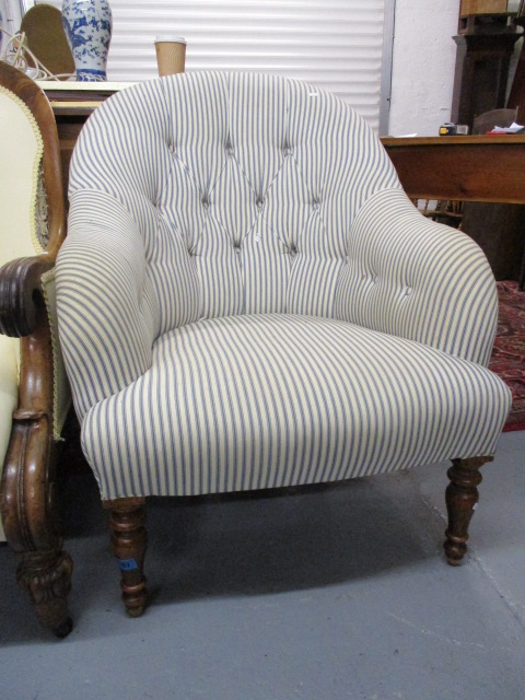 A modern button upholstered armchair, raised on turned, tapered, stained beech legs