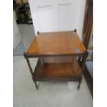 A reproduction mahogany, two tier lamp table with base drawer on turned legs and brass castors, 23