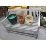 A painted garden bench together with mixed garden pots