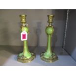 A pair of ceramic over gilt metal candlesticks