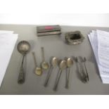 A small selection of silver and silver plate to include sugar tongs, spoons, a salt and a dressing