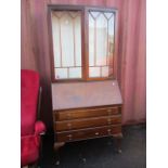 A 1920s mahogany bureau bookcase having astrigal glazed doors and three long drawers below, 76 3/4 h