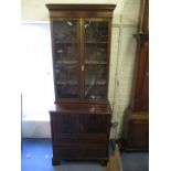 A late Victorian/early Edwardian mahogany bookcase cabinet having twin glazed doors, with cupboard