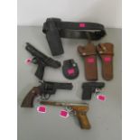 A Webley & Scott Ltd Hurricane air pistol, three other guns and a group of leather pistol holsters