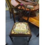 A Georgian oak splat back chair having a needlepoint drop-in seat