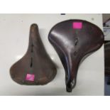 A Lepper vintage leather bicycle seat and a vintage Brooks leather bicycle seat with a Lucas bicycle