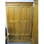 A modern pine double wardrobe above two short drawers on a plinth base, 78h x 47 w, 22d