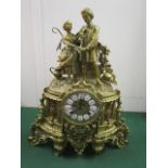 A mid 20th century French gilt brass mantle clock, the ornate case surmounted by a romancing couple,