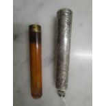 An amber cheroot holder with an 18ct gold plated rim in an Edwardian silver cheroot holder having