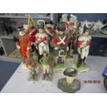 Seven china flasks fashioned as military figures with musical bases, two other figures and a