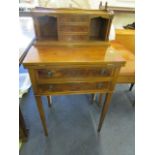 A small yew wood ladies writing desk, the top with three central drawers flanked by open shelves and