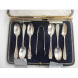 A boxed set of silver to include sugar tongs and spoons
