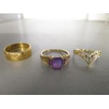 A 9ct gold ring set with amethyst stones, an 18ct gold wedding band and a yellow metal ring, stamped
