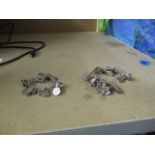 Two silver charm bracelets with a total of thirty seven charms