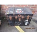 A vintage black painted trunk with leather corners