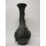 An early 20th century Japanese bronze vase of bolbous form, decorated in relief with two dragons,