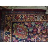 A Persian design carpet with floral sprays on a red ground, 103" x 122"