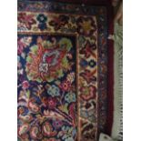 A Persian design carpet with floral sprays on a red ground, 103" x 122"