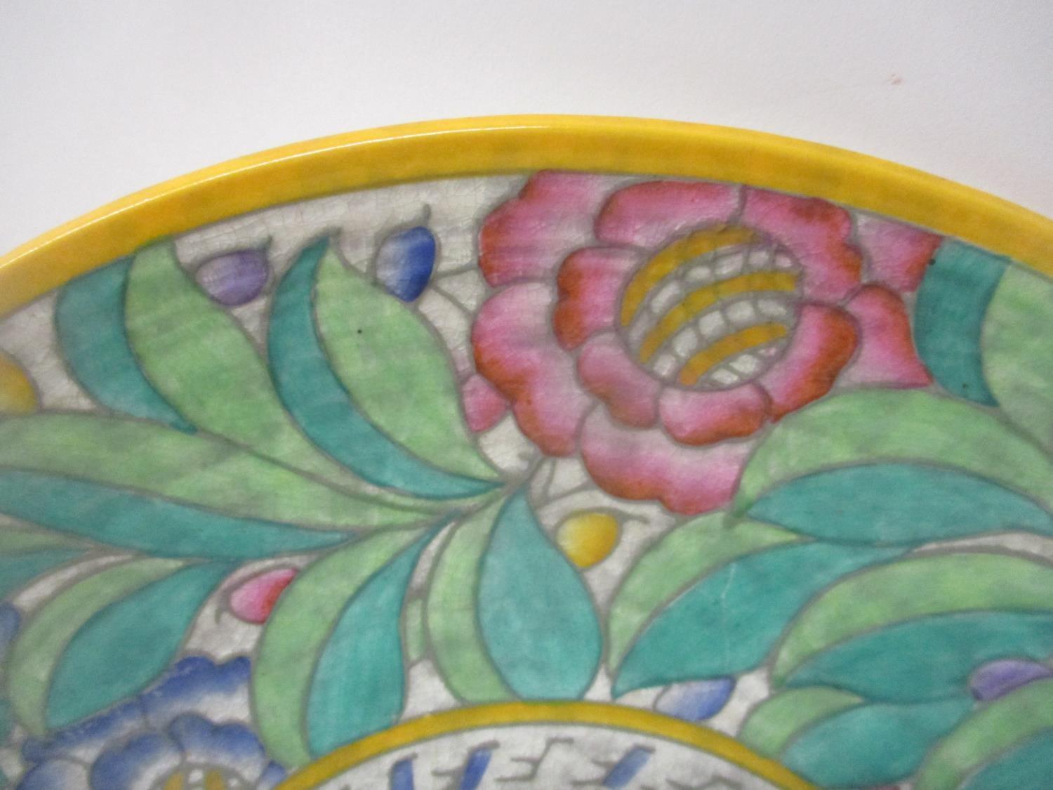 A Crown Ducal, Charlotte Rhead charger decorated with a band of flowers and foliage in green, - Image 2 of 4