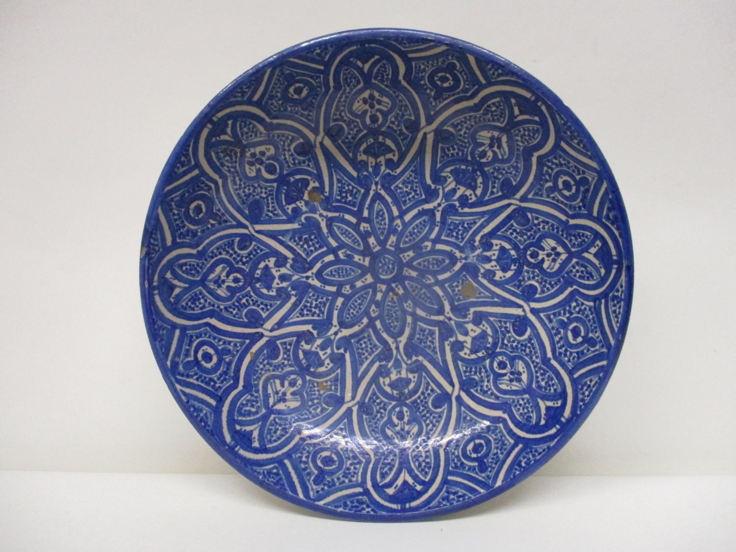 An early 20th century Islamic pottery bowl decorated with panels in blue and white, 13 1/4"dia