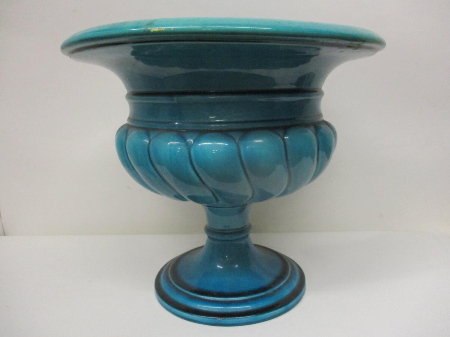 A Burmantoft Faience turquoise glazed Campania pedestal planter with gadrooned ornament on a