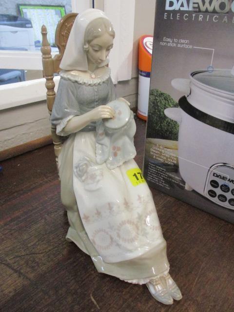 A Lladro figure of a seated lady sewing