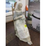 A Lladro figure of a seated lady sewing