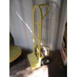 A yellow painted, tubular metal sack barrow