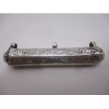 A silver amulet case of hexagonal form with domed ends, engraved with calligraphy around the sides