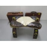 A camel stool with white and brown leather upholstered seat, stamped brass mounts and studwork,