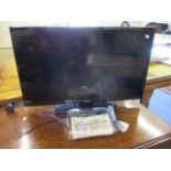 A modern Bush 32' television with remote and instruction book