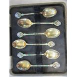 A set of six silver gilt and enamelled coffee spoons, the handles fashioned as flowers, by